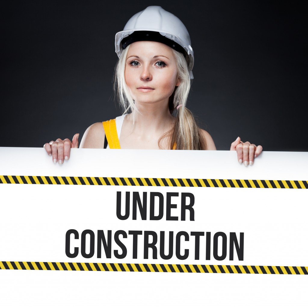 Under construction sign on template board, worker woman